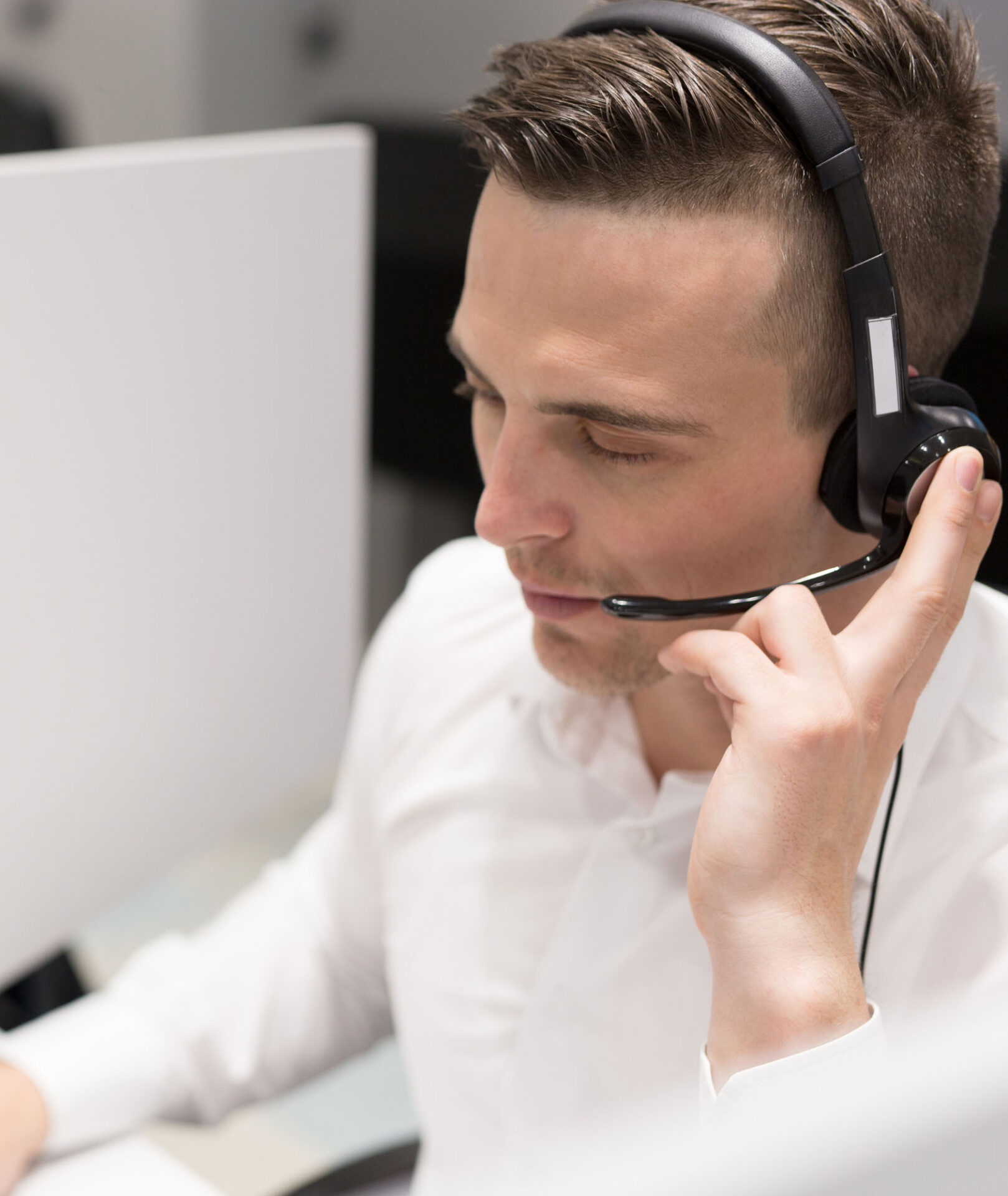 Male employee at the service centre using a headset to speak with a tenant